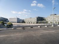 a highway going towards a building near some trees and bushes in front of it in the city