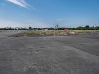 a basketball hoop sits on the corner of an empty parking lot where players are standing