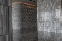 a room with gray marble walls and wooden ceilings as well as a reflection of the door