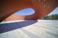 the sculpture is a circular structure on the side of the street, designed like a curved curve