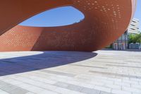 the sculpture is a circular structure on the side of the street, designed like a curved curve