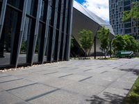 an empty city sidewalk with some benches next to it in the city with tall buildings