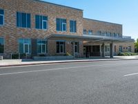 the sidewalk is wide enough to pass by this large building at the corner of the street