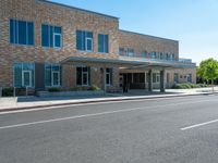 the sidewalk is wide enough to pass by this large building at the corner of the street