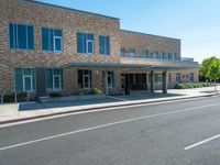 the sidewalk is wide enough to pass by this large building at the corner of the street
