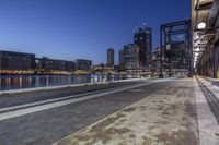 an evening view of the city skyline and water with a bus stop sign by it