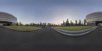 two 360 degrees view of buildings and a parking lot in front of them at dusk