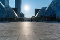 an empty square on top of a building with windows in the middle and one half half reflecting the sun