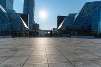 an empty square on top of a building with windows in the middle and one half half reflecting the sun