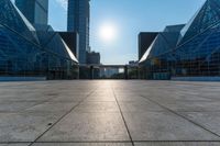 an empty square on top of a building with windows in the middle and one half half reflecting the sun