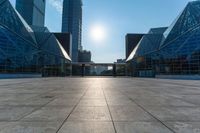 an empty square on top of a building with windows in the middle and one half half reflecting the sun