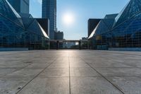 an empty square on top of a building with windows in the middle and one half half reflecting the sun