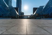 an empty square on top of a building with windows in the middle and one half half reflecting the sun