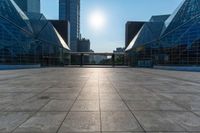 an empty square on top of a building with windows in the middle and one half half reflecting the sun