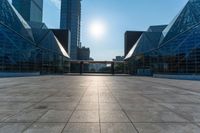 an empty square on top of a building with windows in the middle and one half half reflecting the sun