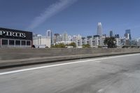 a view of city skyline from the highway showing skyscrapers in background of photograph and a man in distance
