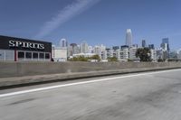 a view of city skyline from the highway showing skyscrapers in background of photograph and a man in distance