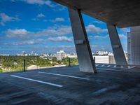 the view from a concrete walkway in a city area with sky and trees around it