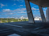 the view from a concrete walkway in a city area with sky and trees around it