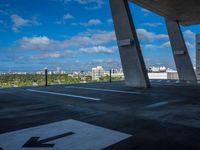 the view from a concrete walkway in a city area with sky and trees around it