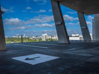 the view from a concrete walkway in a city area with sky and trees around it