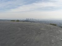 a bike is parked on top of a concrete wall overlooking the city skyline and ocean