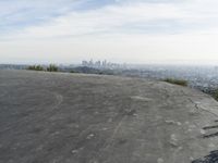 a bike is parked on top of a concrete wall overlooking the city skyline and ocean