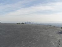 a bike is parked on top of a concrete wall overlooking the city skyline and ocean