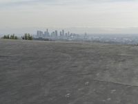 a bike is parked on top of a concrete wall overlooking the city skyline and ocean