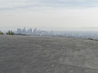 a bike is parked on top of a concrete wall overlooking the city skyline and ocean