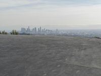 a bike is parked on top of a concrete wall overlooking the city skyline and ocean