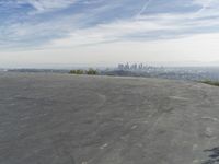 a bike is parked on top of a concrete wall overlooking the city skyline and ocean