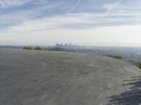 a bike is parked on top of a concrete wall overlooking the city skyline and ocean