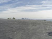 a bike is parked on top of a concrete wall overlooking the city skyline and ocean