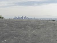a bike is parked on top of a concrete wall overlooking the city skyline and ocean