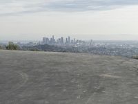 a bike is parked on top of a concrete wall overlooking the city skyline and ocean