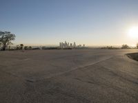 the sky is clear and empty of cars or vehicles and skyscrapers as the sun sets over a large urban skyline