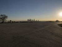 the sky is clear and empty of cars or vehicles and skyscrapers as the sun sets over a large urban skyline