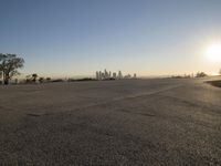 the sky is clear and empty of cars or vehicles and skyscrapers as the sun sets over a large urban skyline