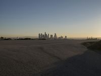 the sky is clear and empty of cars or vehicles and skyscrapers as the sun sets over a large urban skyline