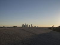 the sky is clear and empty of cars or vehicles and skyscrapers as the sun sets over a large urban skyline