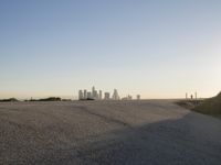 the sky is clear and empty of cars or vehicles and skyscrapers as the sun sets over a large urban skyline