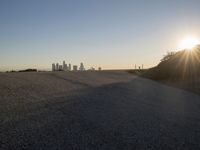 the sky is clear and empty of cars or vehicles and skyscrapers as the sun sets over a large urban skyline