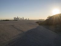 the sky is clear and empty of cars or vehicles and skyscrapers as the sun sets over a large urban skyline