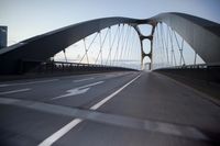 a car going over a bridge at sunset with city skyline in the background as seen from a moving vehicle