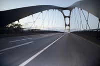 a car going over a bridge at sunset with city skyline in the background as seen from a moving vehicle