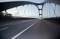 a car going over a bridge at sunset with city skyline in the background as seen from a moving vehicle