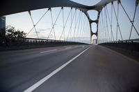 a car going over a bridge at sunset with city skyline in the background as seen from a moving vehicle