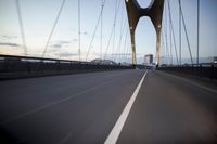 a car going over a bridge at sunset with city skyline in the background as seen from a moving vehicle