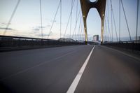 a car going over a bridge at sunset with city skyline in the background as seen from a moving vehicle